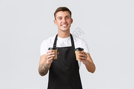 小型企业 咖啡店 咖啡馆和餐馆的概念 英俊有魅力的咖啡师 服务员用纸杯递外卖咖啡 为客人准备订单 在白色背景下销售饮料图片