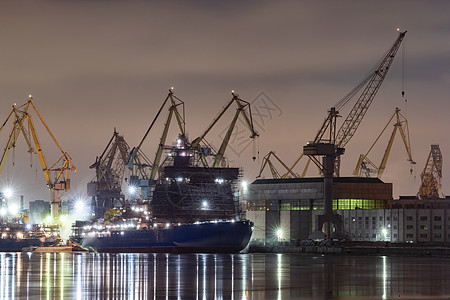 夜间建造核破冰器 冬季寒冷的波罗的海造船厂起重机 Neva河上蒸汽 河流平滑地表 雾雾货运渔船送货血管货轮城市货物港口机器船厂图片