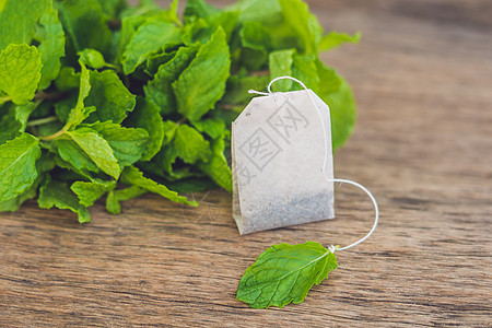 木制背景茶袋 有新鲜美莉萨 薄荷茶 有薄荷概念的茶收藏保健草本植物木头英语植物健康香气茶包宏观图片