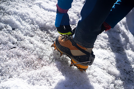 人类正在攀爬冰川上的抽筋山脉首脑靴子远足冰爪运动旅行男人登山牵引力图片