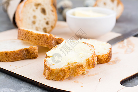 清晨美味早餐 新鲜的包面包三明治 餐桌上切菜板上加黄油和奶油图片