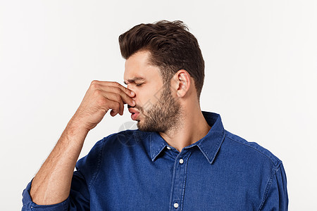 男人用鼻子抵挡灰色背景的臭气味 他被孤立在灰色背景上白色进攻手指成人男性呼吸鬼脸厌恶气体香气图片