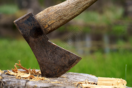 木柄卡在树桩上的旧的生锈斧子 背景模糊 木原木堆积 森林本底碎木中大斧头记录器乐器金属木头日志切割刀刃林业工具工作图片