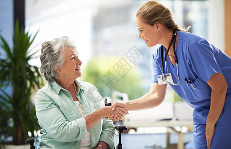 一名坐在轮椅上 面带微笑的高级妇女与一位医生握手的照片关爱工人会议成人疗养院照顾者生活卫生女性保健图片