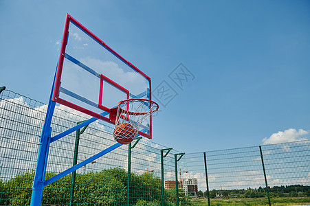 篮筐里有一个篮球 在篮球比赛期间在夏季运动场上进球图片