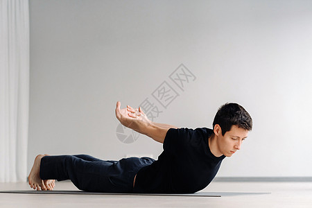 一个穿黑色T恤火车的男人 躺下在健身房做伸展肌肉成人活动运动装运动闲暇瑜伽讲师力量护理图片