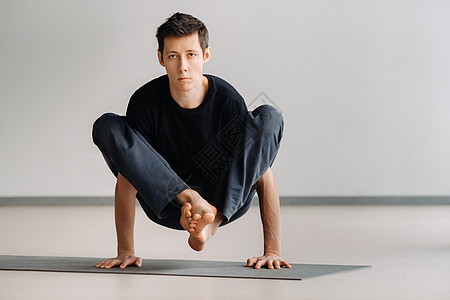 一个穿黑色T恤火车的男人 躺下在健身房做伸展运动垫运动员运动衣服姿势运动装瑜伽力量护理姿态图片