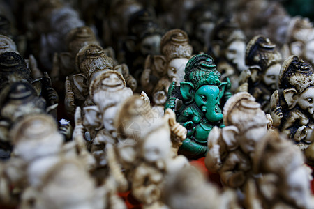 Ganesh的石雕像是绿色的 与印度市场对面的光块Ganesh形成对比手工寺庙工艺手工业旅游雕塑雕像收藏游客崇拜图片