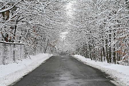 在冬季用雪和冰块修补劣质沥青路 在恶劣的冬季天气中运输和旅行的概念 12月31日背景图片