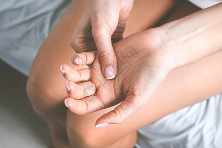 患有手痛或手指痛的妇女 手麻或四肢麻木 按摩痛苦的手图片