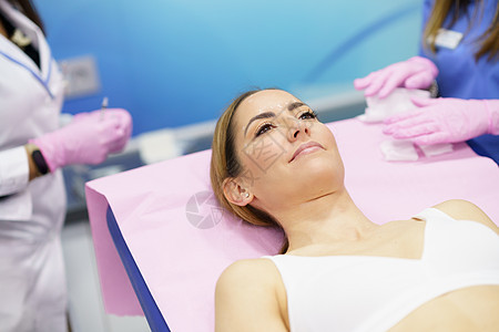 中年妇女躺在一个审美诊所的担架上图片
