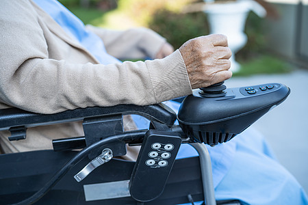 护理医院病房远程控制电动轮椅的亚洲老年或老年老妇人患者 健康强健的医疗理念微笑旅行机动性轮椅祖母极乐男人女性护理女士图片