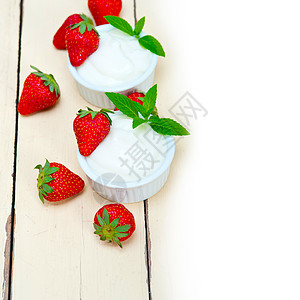 希腊有机酸奶和草莓薄荷早餐旋转叶子饮食小吃乳制品木头牛奶水果图片