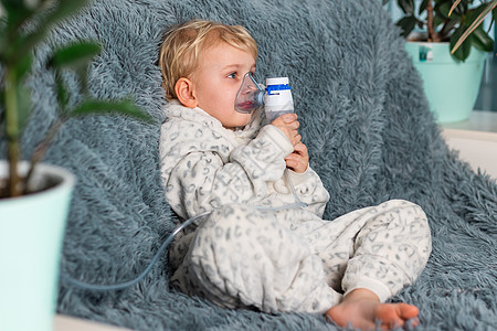 可爱的男婴用雾化器设备吸入 生病的孩子手里拿着吸入器 在家里通过吸入器呼吸疾病痛苦病人哮喘支气管炎面具攻击喷雾器男生药物图片