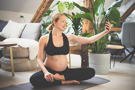 年轻快乐开朗的美丽孕妇在产假期间用手机自拍 同时保持健康 运动和活跃 孕产 怀孕 瑜伽概念护理锻炼女性母亲生活电话社交媒体邮政婴图片
