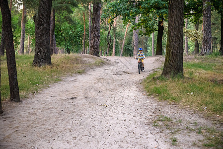 赛车手骑着沙丘 在离路轨上娱乐自行车速度男生骑士男性运动员闲暇车轮山地车图片