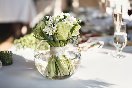 豪华婚礼宴会的餐桌布置 桌子上美丽的花朵花瓶玻璃用餐盘子奢华环境派对餐厅蜡烛桌布图片