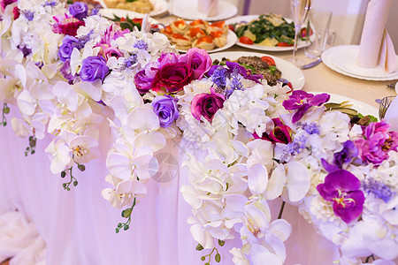 在餐桌上盛满多彩的结婚花束兰花图片