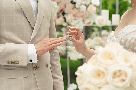 婚礼订婚戒指 一对已婚夫妇在婚礼上交换结婚戒指 新娘把戒指戴在新郎的手指上图片
