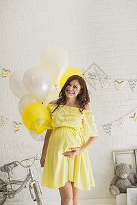在演播室穿黄色礼服的漂亮孕妇孩子生活自行车气球母性身体父母男生成人女性图片