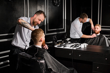 大师在理发店剪头发和胡子 美发师用剪刀和金属梳子做发型工作客户理发店铺护理男性修饰男人胡须沙龙图片