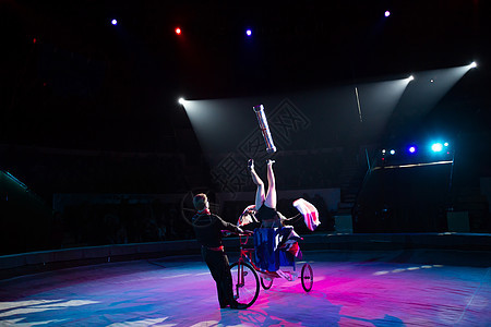 在马戏团圆顶下骑自行车的杂耍家女性展示魔术师娱乐运动员高跷女孩绳索戏法者灵活性图片
