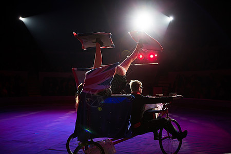 在马戏团圆顶下骑自行车的杂耍家魔术师绳索灵活性乐趣娱乐空气女孩男人杂技女士图片