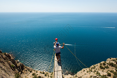 绳子从悬崖上跳下来 在水中用绳子男人连衣裤跳绳安全勇气男性粗糙化高度风险岩石图片