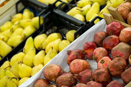 在超市用成熟的石榴和梨子作对图片