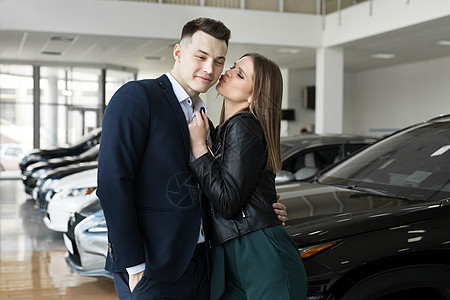 一对夫妇的男女 很高兴在汽车经销商买一辆新车图片