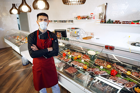 在超市肉摊旁站着的 年轻男店主肖像员工商业熟食男人顾客工作标志助手杂货店微笑图片