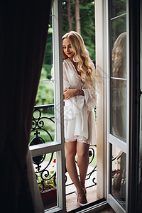 金发美女新娘在阳台上走来走去 等着她的新郎内衣冒充女孩房间女性长发身材白色婚礼化妆品背景图片