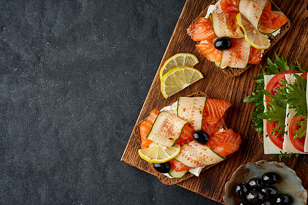 丹麦传统三明治 黑黑黑麦面包和鲑鱼奶油黄瓜蔬菜午餐早餐面包美食食谱烹饪砧板图片