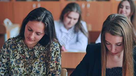 上课时课桌边的班级11年级学生 是俄罗斯学校的学生考试女孩帮助知识课堂男性同学男生教育微笑图片
