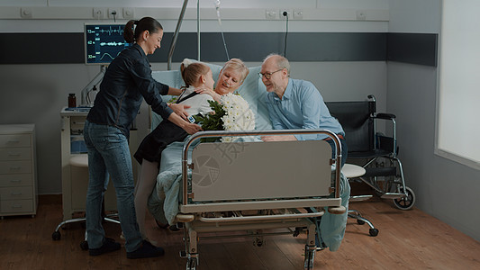 母亲和孩子在医院病房床上看病的奶奶花朵高清图片素材