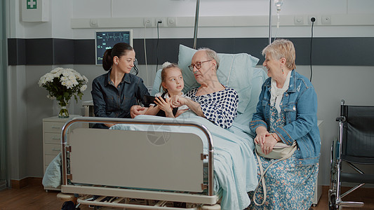 老人和侄女在医院病房床上浏览智能手机的互联网图片