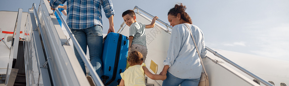 父母的背影 有两个孩子要上飞机 白天登机 准备暑假 日间假期勘探旅行妻子童年男性乘客儿子手提箱女士丈夫孩子们高清图片素材