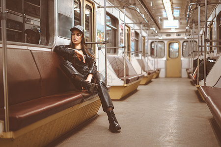 皮衣夹克 皮裤和Akle Boots的野蛮女人单独坐在一辆火车上图片