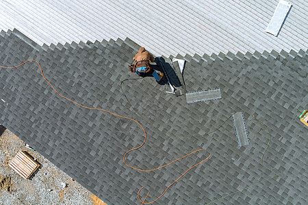 屋顶屋顶机上的沥青瓦安装正在将沥青瓦钉在屋顶结构上图片