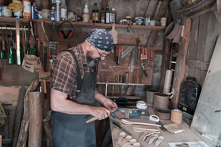 配木制产品和工具的勺子大师工作间木工工匠胡须男人作坊雕刻木制品男性创造力工作图片