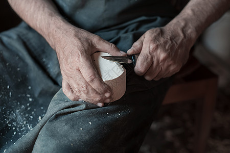 手用木头雕刻杯子 用凿子特写 木制车间 木制厨具的制作过程工艺木材桌子木匠工作台创造力男性雕刻师勺子作坊图片
