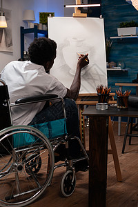 坐在轮椅上制造影子的年轻男子艺术家图片