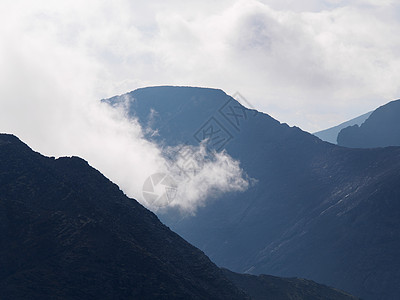 云层中的山峰 背光下一连串灰色山脉登山丘陵阳光景点比丘旅游太阳废墟岩石基岩图片