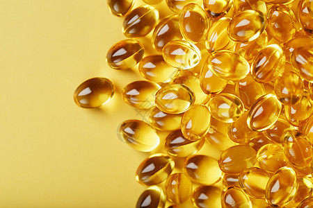 在无空间的黄色背景上 用维他命D3金胶囊药片治疗药物营养胶囊脂肪酸工作室鱼油制药饮食图片
