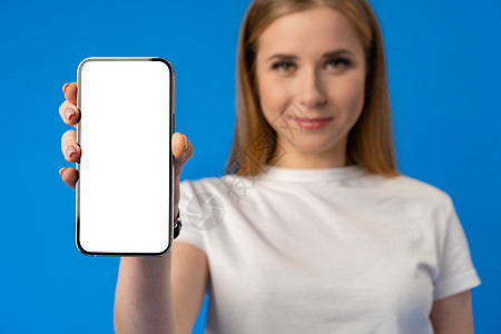 年轻女性对蓝色背景的孤立智能手机屏幕指手指尖展示相机商业技术学生小样促销广告空白女士背景图片