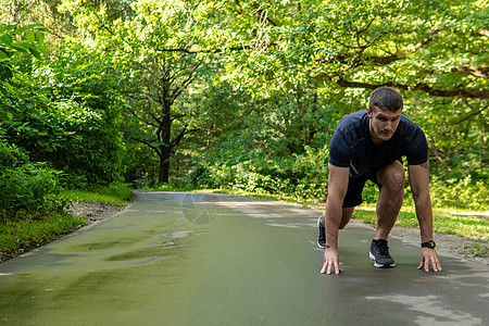 一名男子运动员在户外的公园里跑步 在森林周围 橡树绿草年轻持久的运动员健康运动森林 健身年轻健康马拉松 公园外 成人休闲跑者伸展图片