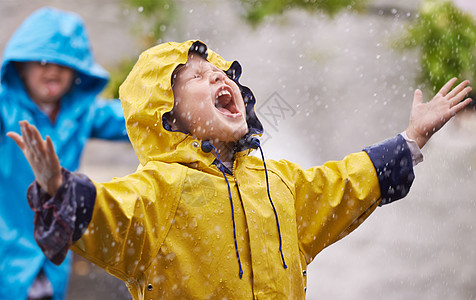 他们喜欢下雨 被一个年轻兄弟姐妹在雨中玩耍的镜头拍到图片