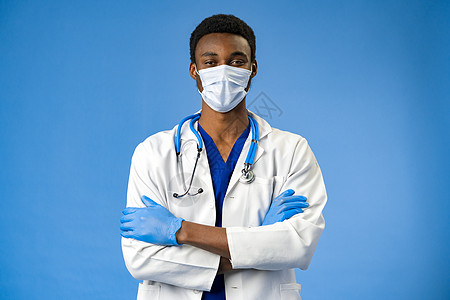 蓝色工作室的面罩和手套上的自信黑人医生工人男人保健医院工作安全手术助手青年奉献图片