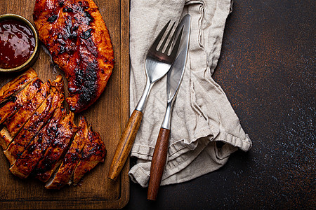 配有红酱汁和切片在木制板上的火鸡或鸡排木板倾斜胸部乡村饮食厨房盘子菜单烧烤营养图片