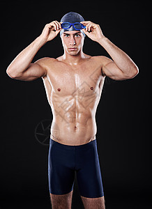 片场肖像画 一个年轻男性游泳运动员带护目镜和帽子的摄影师图片